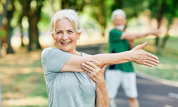 Gymnastik im Park Frau Dehnt sich im Park.
